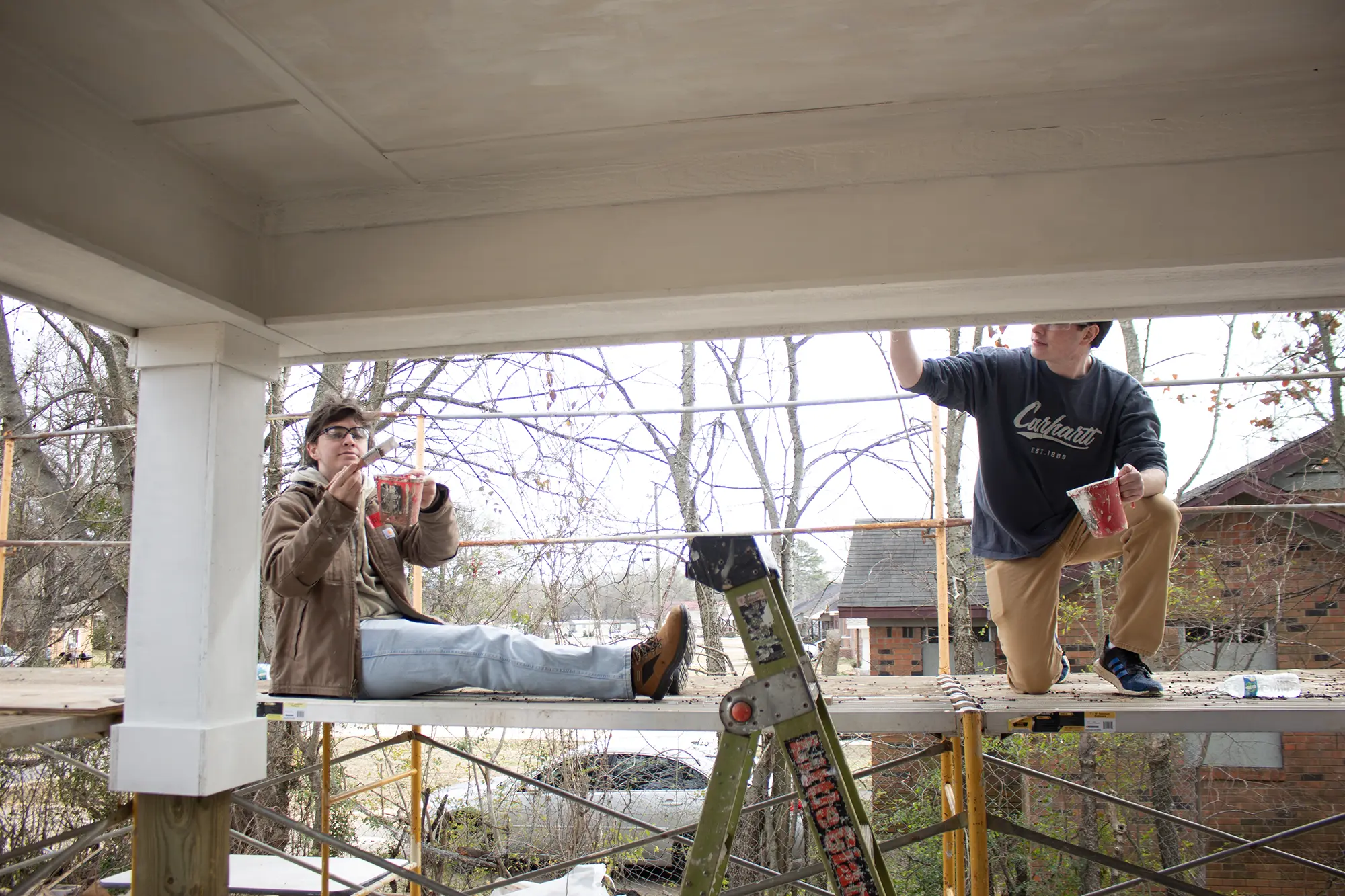 UA Habitat members painting from scaffolding